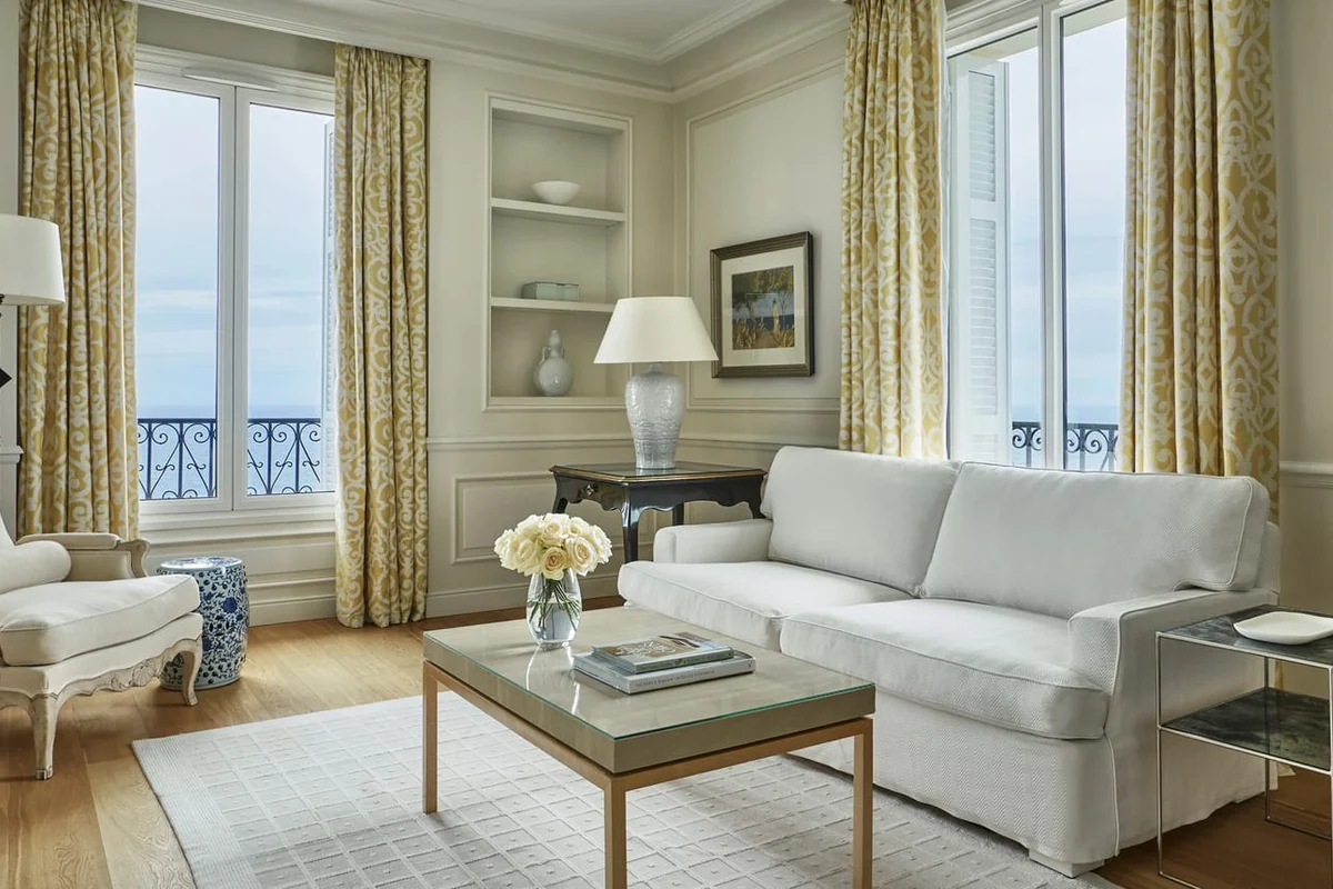 Salão elegante com flores brancas, mobiliário clássico e vista para o Mediterrâneo